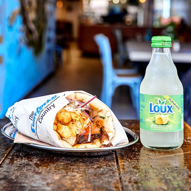 Close-up of juicy lamb gyros wrapped in warm pita bread with fresh vegetables and tzatziki sauce