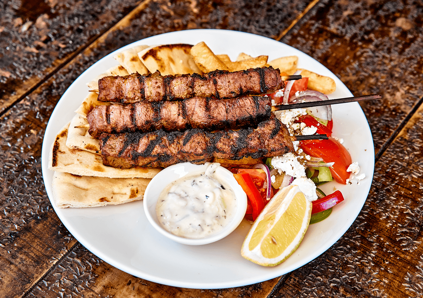 Grilled Greek lamb and souvlaki plate served with pita, salad and tzatziki
